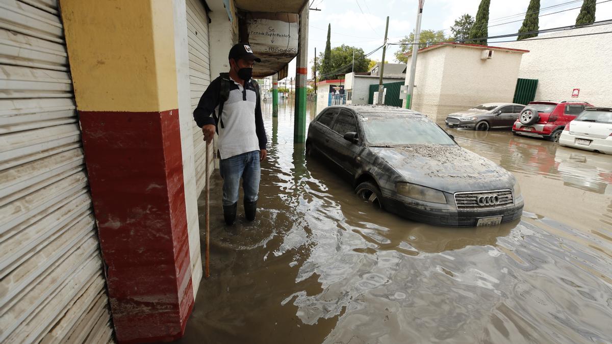 Afectados por lluvias en México rescatan entre el lodo lo poco que les queda.