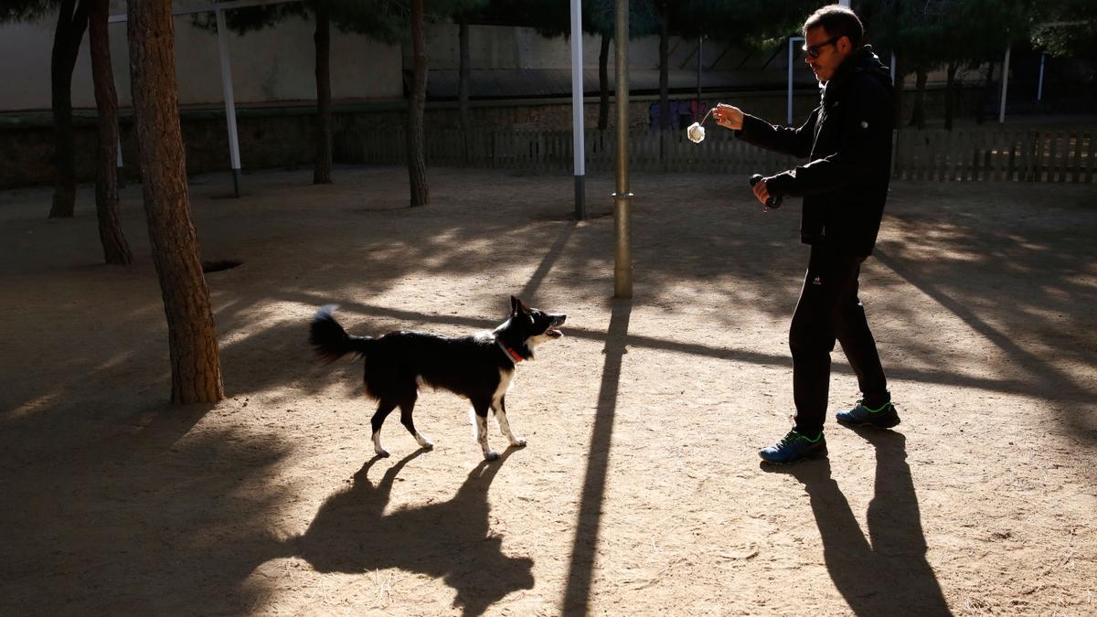 Un propietario con su perro en el parque del Clot, en Barcelona.