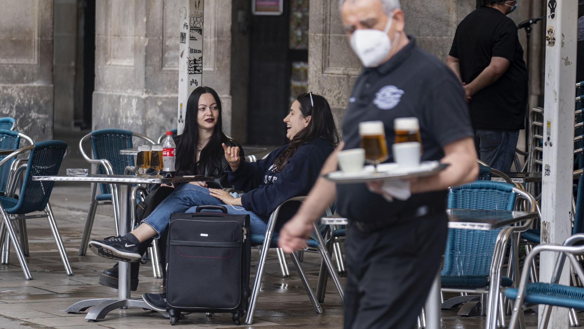 Dos turistas en la terraza de un bar en la plaza Real de Barcelona.