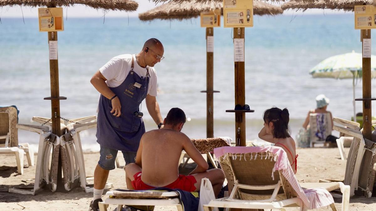 Dos turistas disfrutan de un chiringuito en la playa de Pedregalejo.