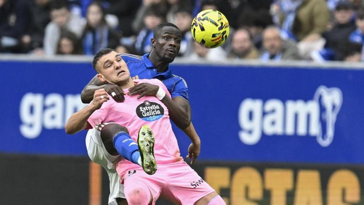 Jutglà disputa el balón mientras es agarrado por Eric Bailly en un lance del partido en el Carlos Tartiere.