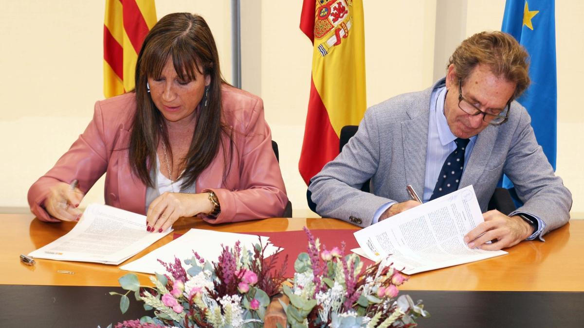 El conseller de Sanidad, Miguel Mínguez, firmando el convenio con su homóloga de Aragón, Sira Repollés.