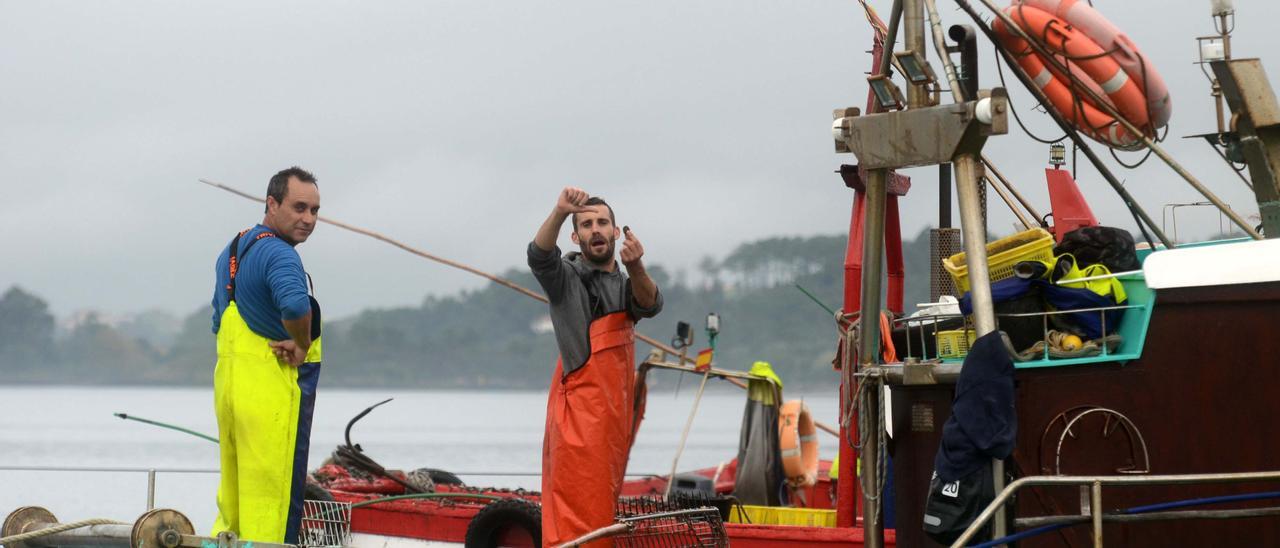 Uno de los “rañeiros” hace un gesto evidente que demuestra que el libre marisqueo está acabado.