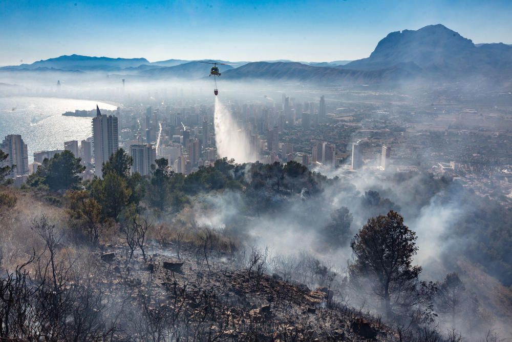 Los bomberos trabajan para sofocar un incendio en el parque de Serra Gelada