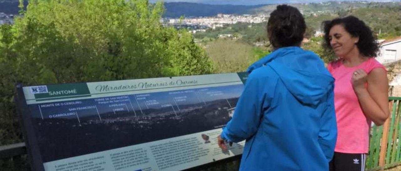 Dos mujeres miran un panel informativo en el Castro de Santomé.   | // F. CASANOVA