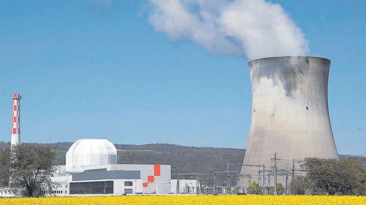 Un camp de colza davant la central nuclear de Leibstadt, a Suïssa. | ARND WIEGMANN / REUTERS
