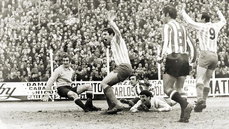 Panadero Díaz, en el suelo, marca un gol de cabeza en un partido entre Racing y Estudiantes.