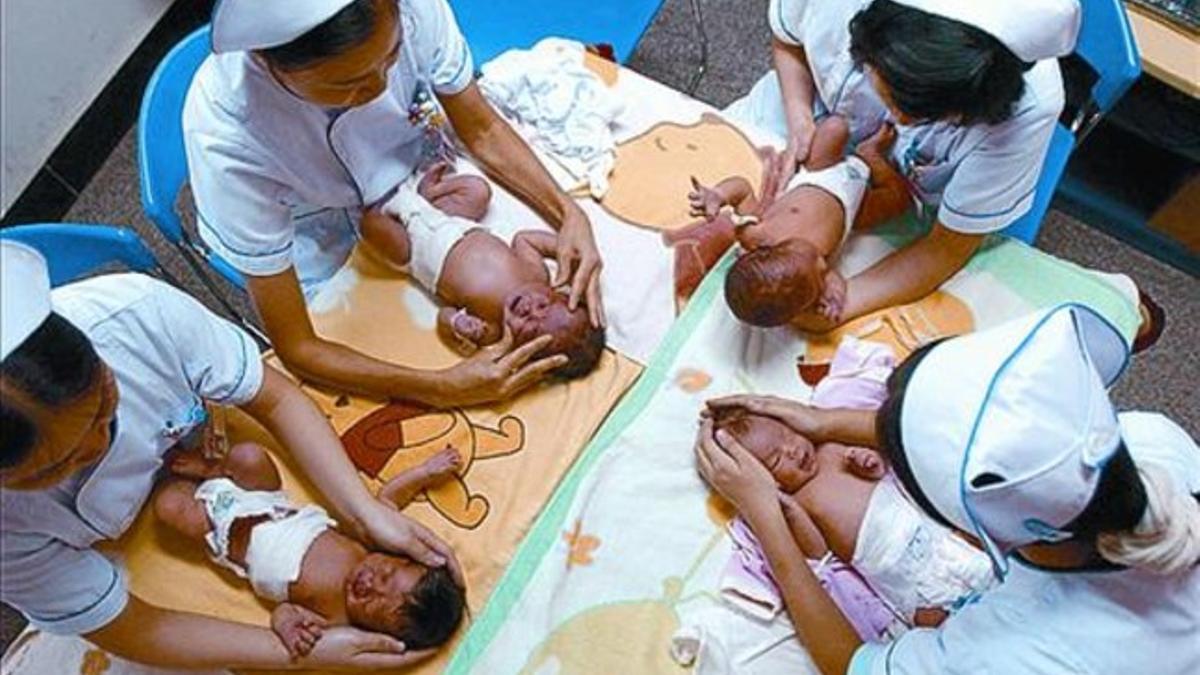 Un grupo de enfermeras chinas masajean a bebés en Chongqing.