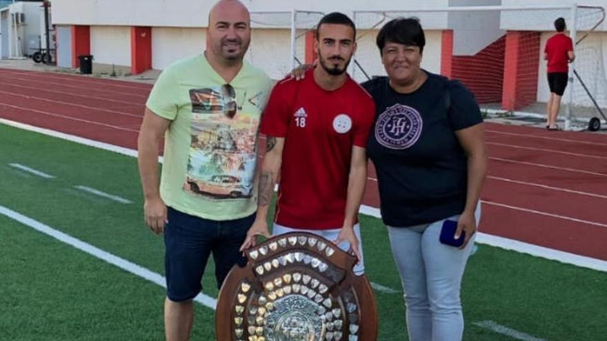 Giovanni, mostrando el trofeo de campeón de Gibraltar junto a sus padres.