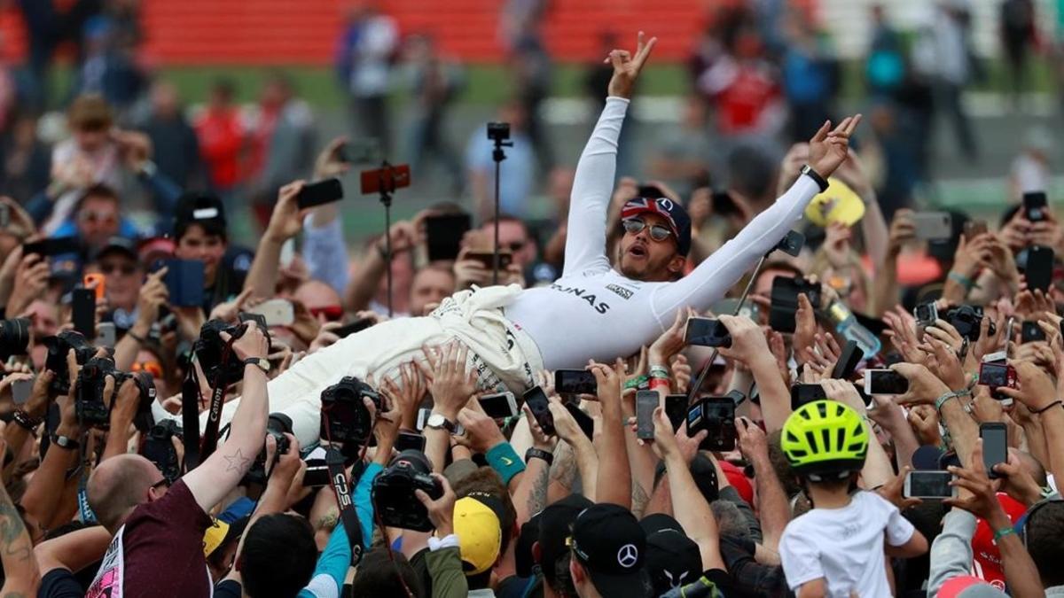 Lewis Hamilton, vencedor en Inglaterra, es manteado por su equipo.