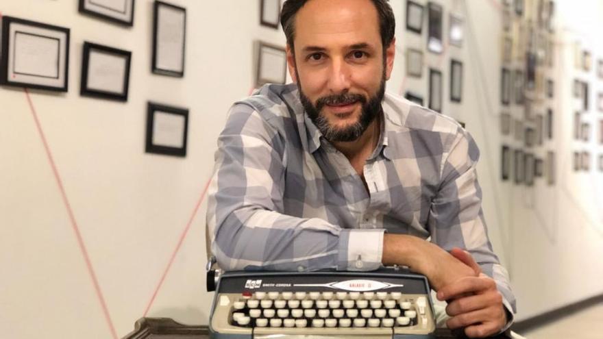 Diego Romero, con la máquina de escribir y los tuits y posts enmarcados.