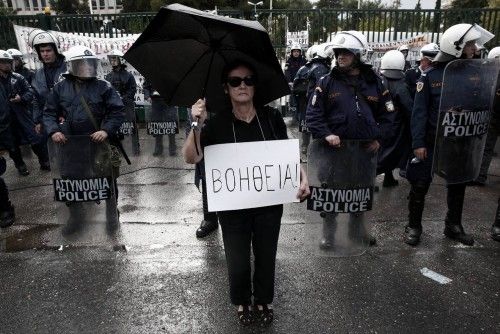 Manifestante se pone delante de la policía frente a la sede de la televisión estatal ERT (Grecia).