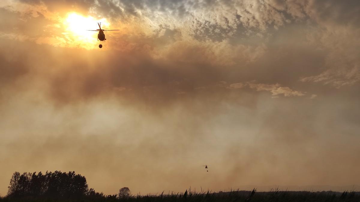 Dos helicópteros se alejan tras descargar agua en una parte de Santa Croya.