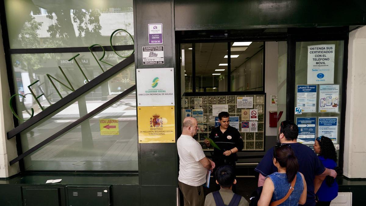 Varias personas migrantes hacen colas en la oficina de la Seguridad Social para la regulación de su situación en España.
