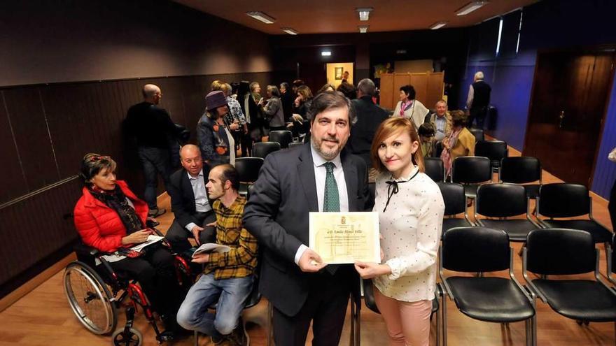 Emilio Alonso recibe el premio de manos de la concejala Rosa Morán.