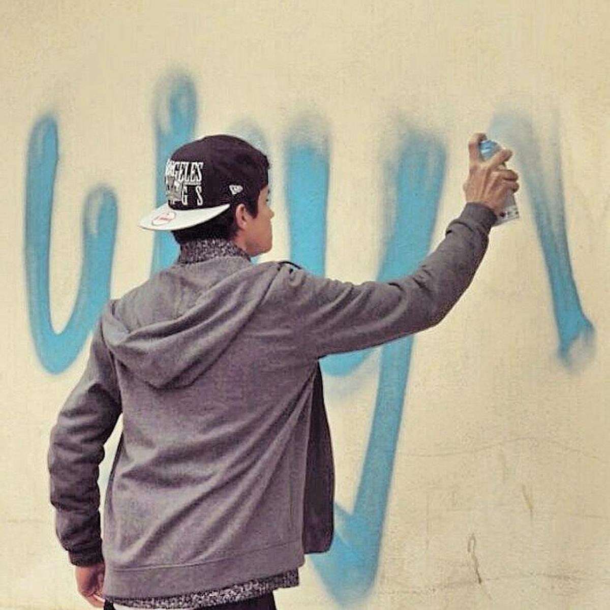 Gino Milanesio, aka Weys, escribiendo sobre un muro durante su época como grafitero.