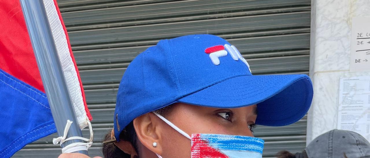 Una manifestante con una bandera de Cuba durante la protesta.