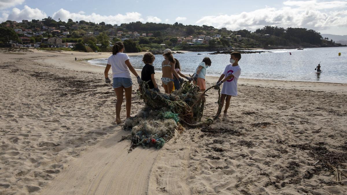 Un grupo de niños retira basura en la plata de Limens (Pontevedra)