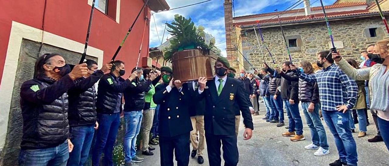 Miembros del COE portan a hombros el féretro, a su paso bajo el arco de bastones que formaron los esquiadores, ayer, al término del funeral. | C. M. B.