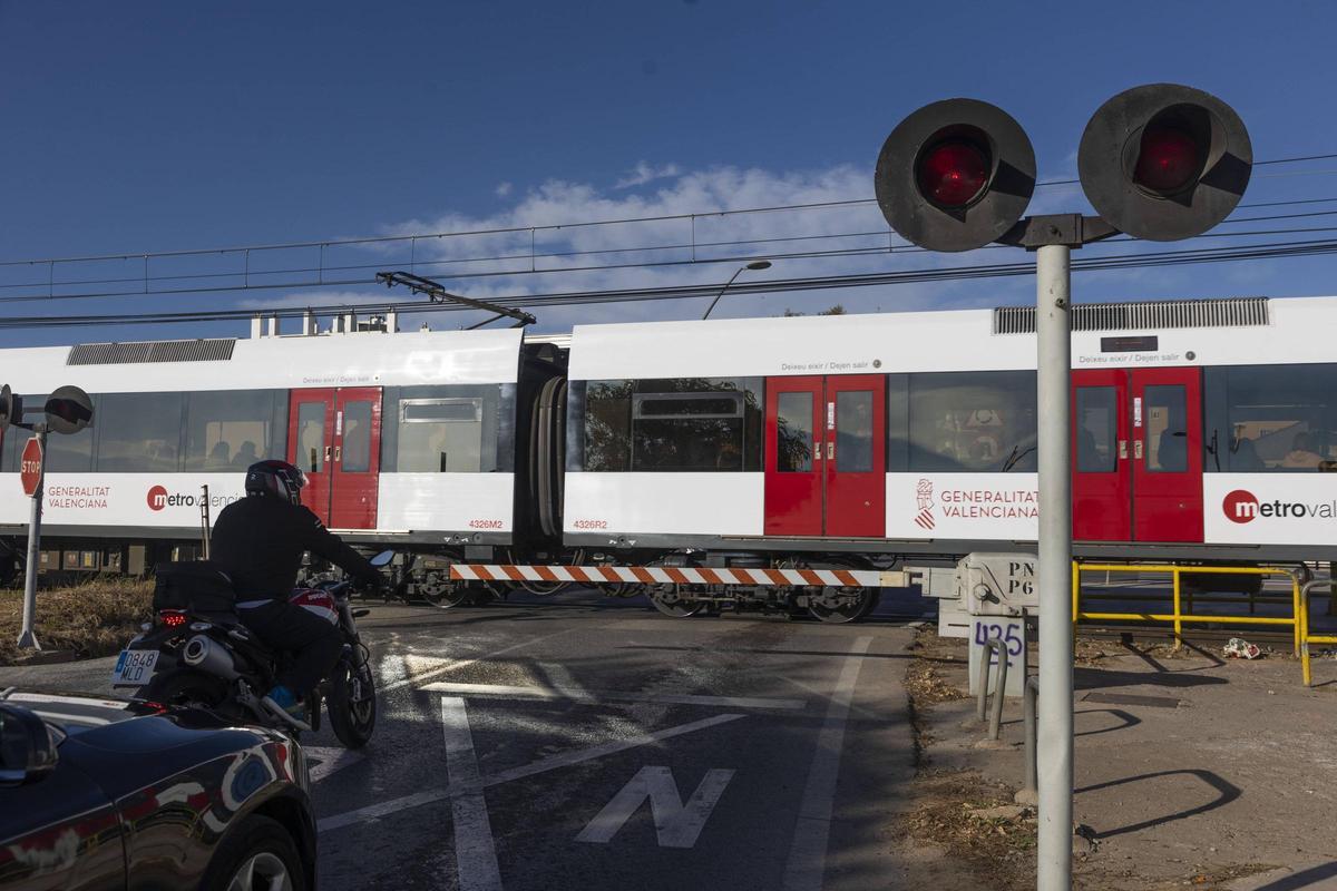 Un metro atraviesa el paso a nivel de Paterna, en la carretera de Manises