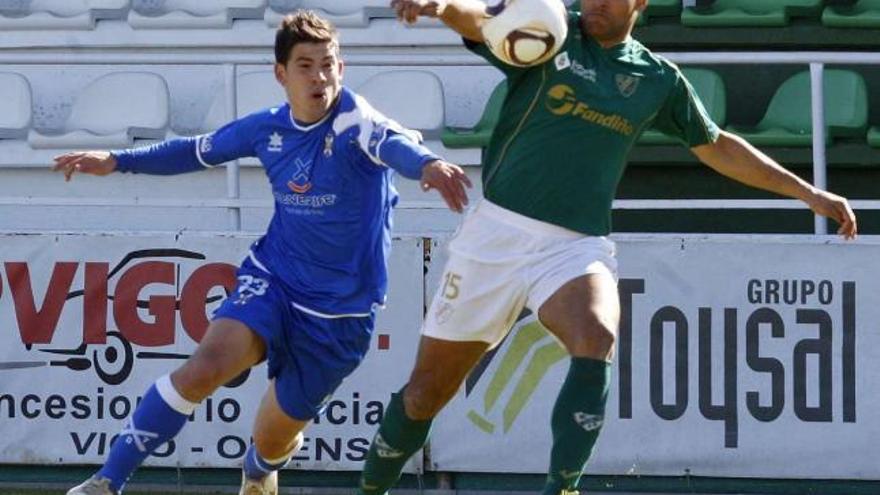 Yago, autor de los dos goles del Coruxo, despeja un balón ante el acoso de un jugador del Tenerife, el pasado domingo. // Ricardo Grobas
