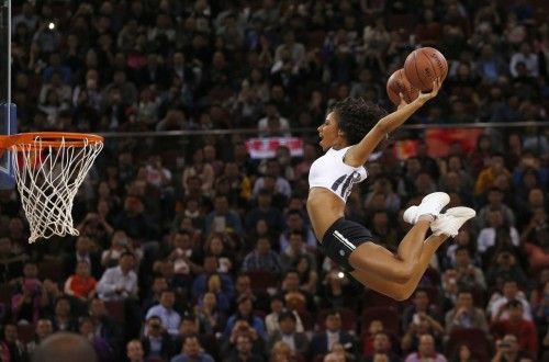 Un miembro del equipo de animadoras salta a encestar durante una actuación en el partido de baloncesto de la NBA entre Sacramento Kings y Brooklyn Nets en Beijing