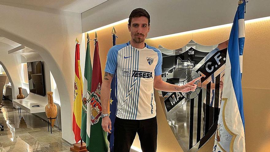 Stefan Scepovic, nuevo jugador del Málaga CF, posa con la bandera blanquiazul