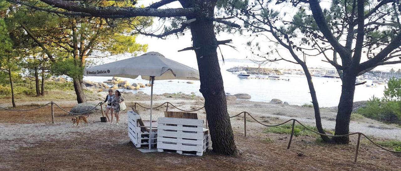 El exterior del chiringuito Playa Portiño, situado sobre las dos playas caninas de O Grove y con vistas sobre el puerto de Pedras Negras y la isla de Ons, al fondo. // FdV