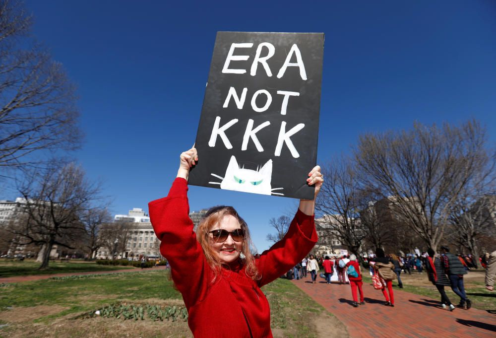 A protester holds a sign aloft as she and ...