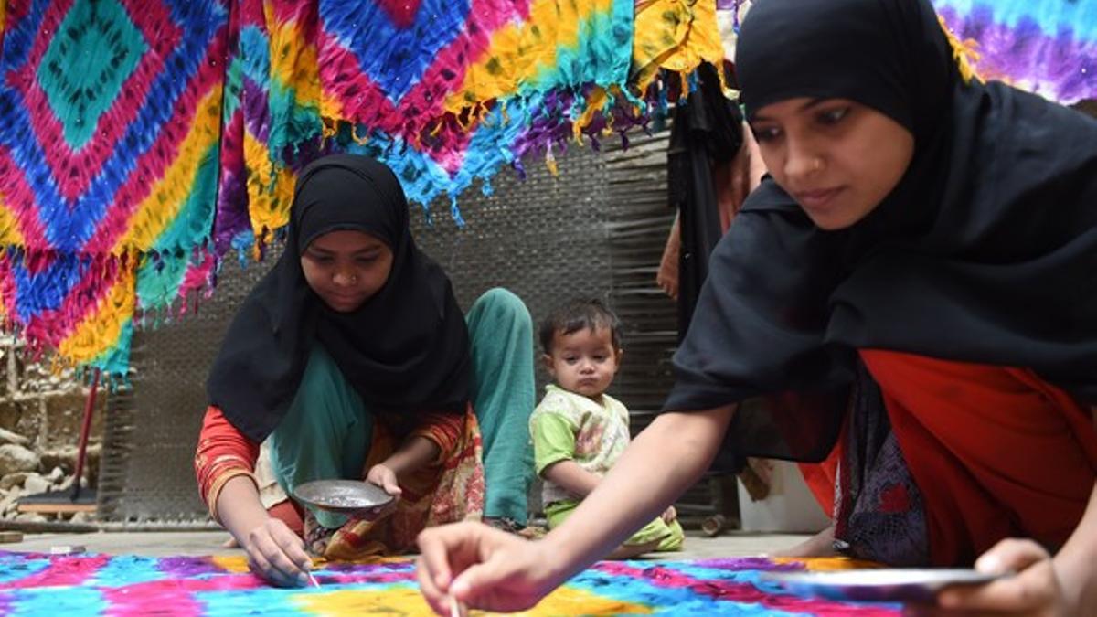 Trabajadoras paquistanís confeccionan alfombras en su casa de Karachi, este lunes.