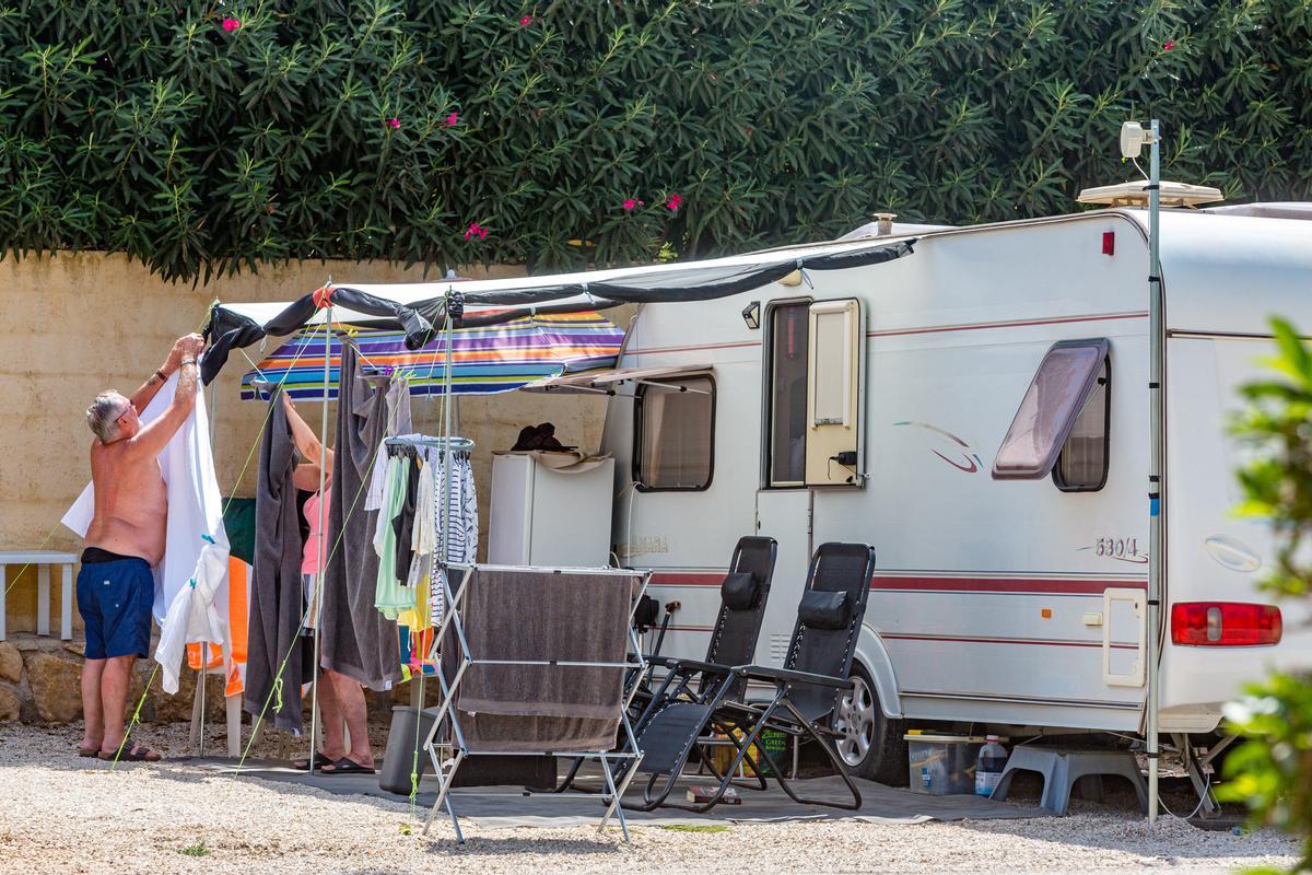Dos personas montan un toldo en el camping Arena Blanca de Benidorm.
