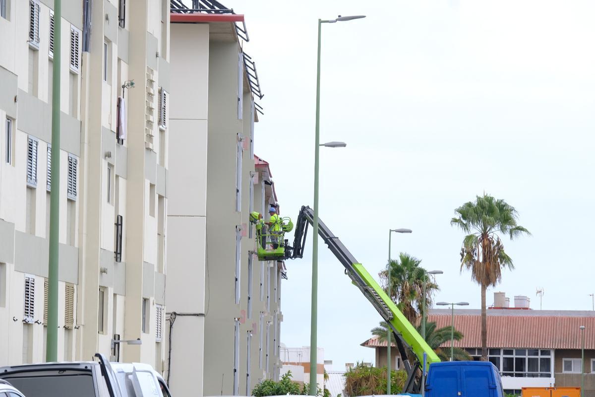 Operarios pintan una de las fachadas del barrio.