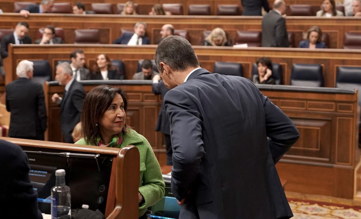 El presidente del Gobierno, Pedro Sánchez, conversa con la ministra de Defensa, Margarita Robles, durante su comparecencia en el Congreso este miércoles.