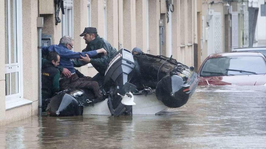 Agentes de la Guardia Civil recogen a un vecino en zódiac durante la inundación, en marzo de 2016 en Sada.