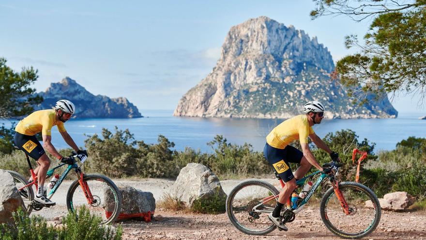 El ibicenco Enrique Morcillo, a la derecha, durante la pasada edición de la Vuelta a Ibiza MTB a su paso por la zona de Cala d’Hort, con es Vedrà al fondo. | JON IZETA