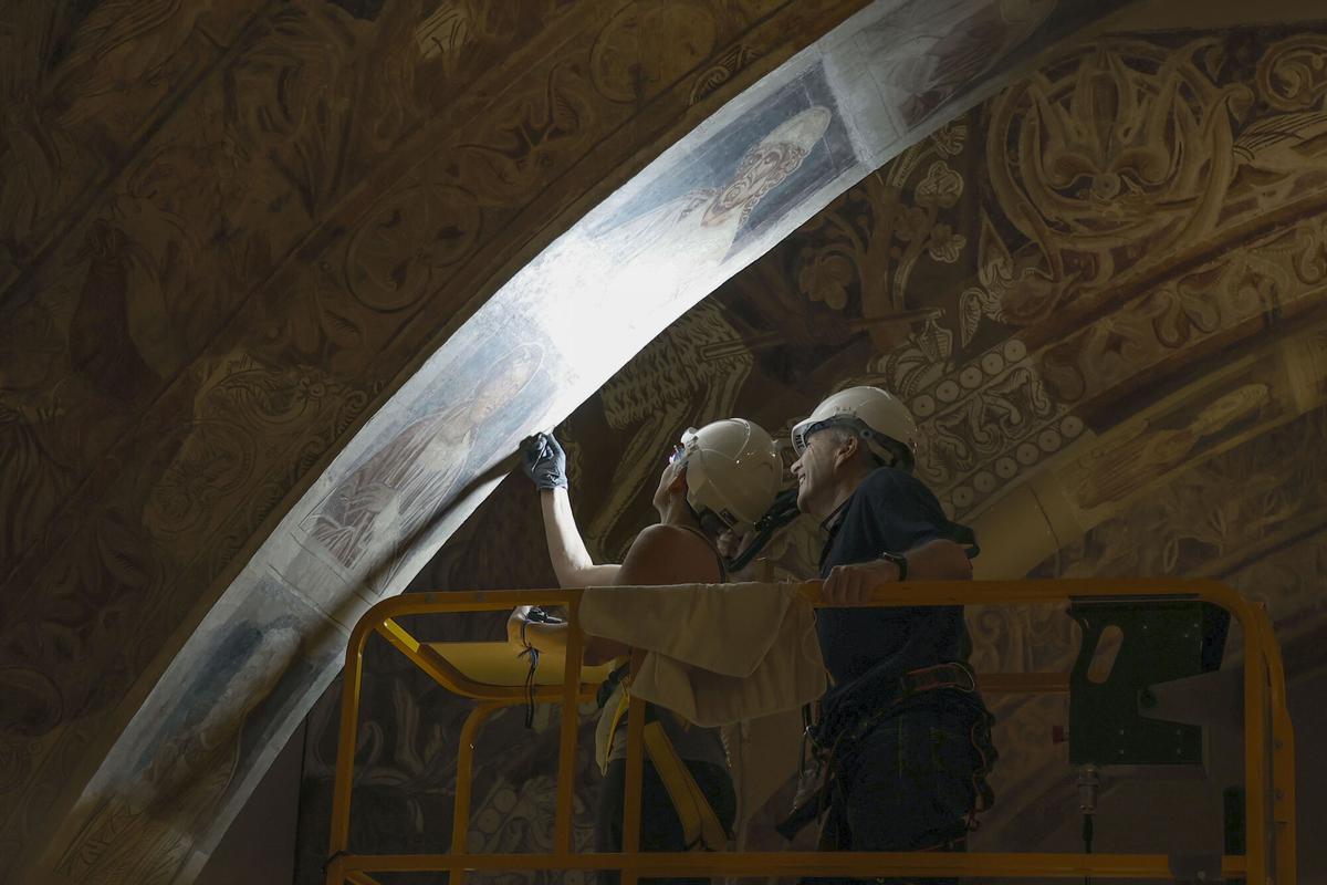 Dos técnicos analizando las pinturas del monasterio de Sijena en el Museo Nacional de Arte de Cataluña (MNAC), el pasado mes de julio. EFE/Andreu Dalmau