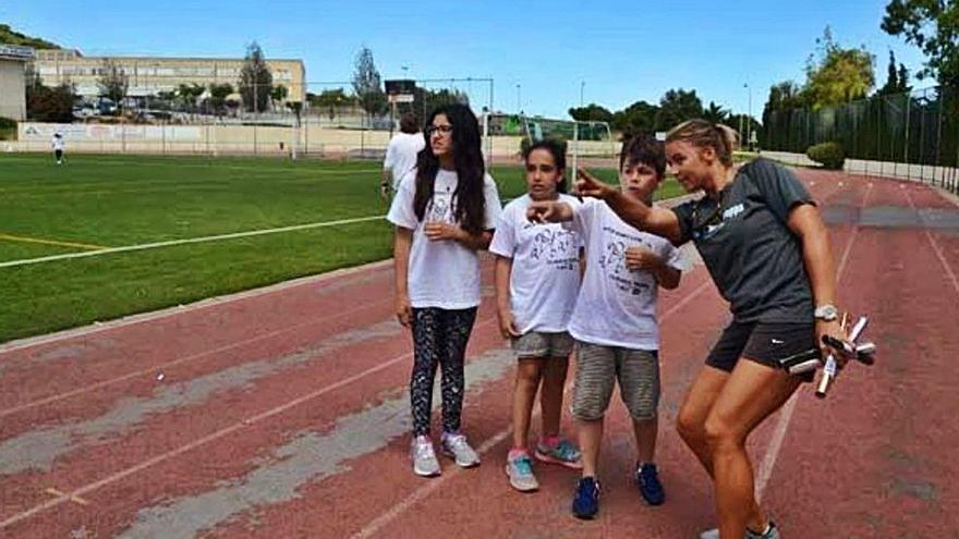 Unos jóvenes atletas conversan en la maltrecha pista de Capdepera.