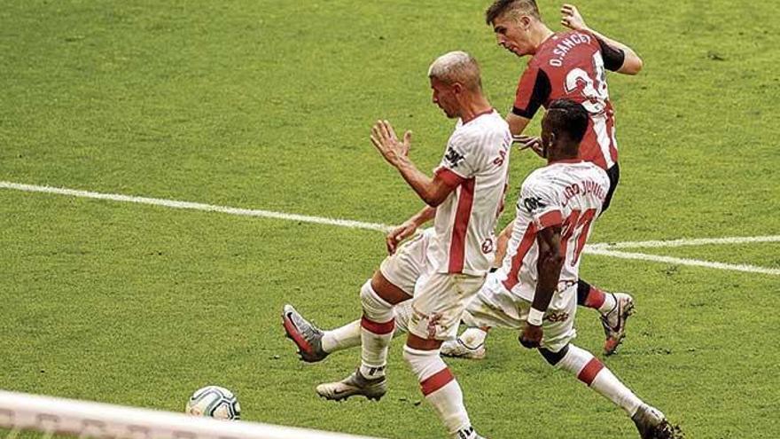Salva Sevilla y Lago intentan frenar el remate de Sancet en el segundo gol del Athletic, el sábado.