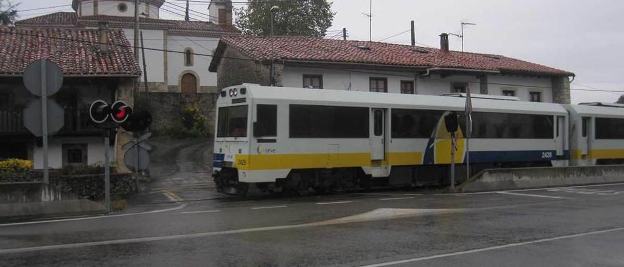 Un tren cruza el paso a nivel de Puertas, en Llanes.