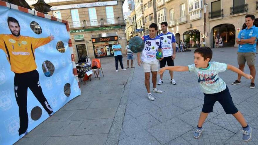 Un niño tira a portería ante la atenta mirada de varios jugadores del Cisne. // Gustavo Santos