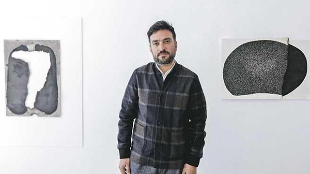 Ali Kaaf posa junto a algunas de sus obras, en la primera muestra individual en la isla.