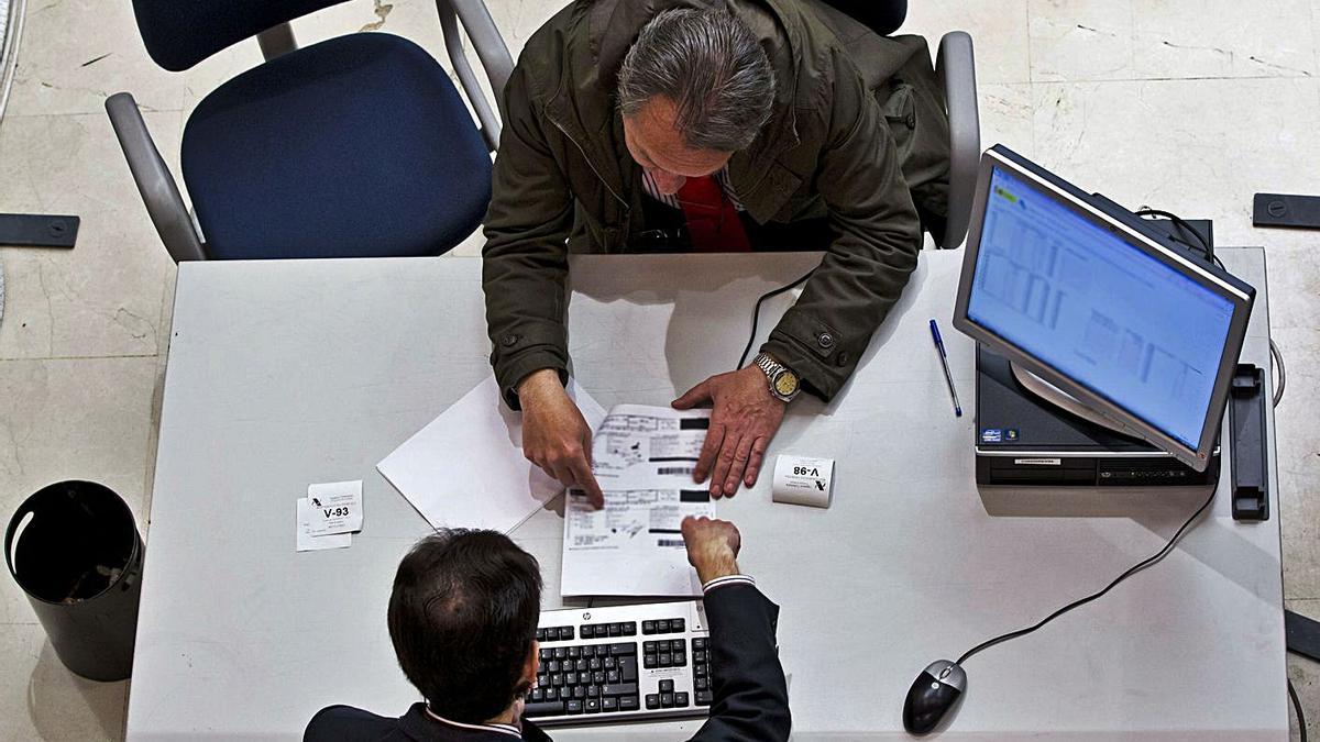 Un hombre realiza un trámite en una administración. | L. O. Z.