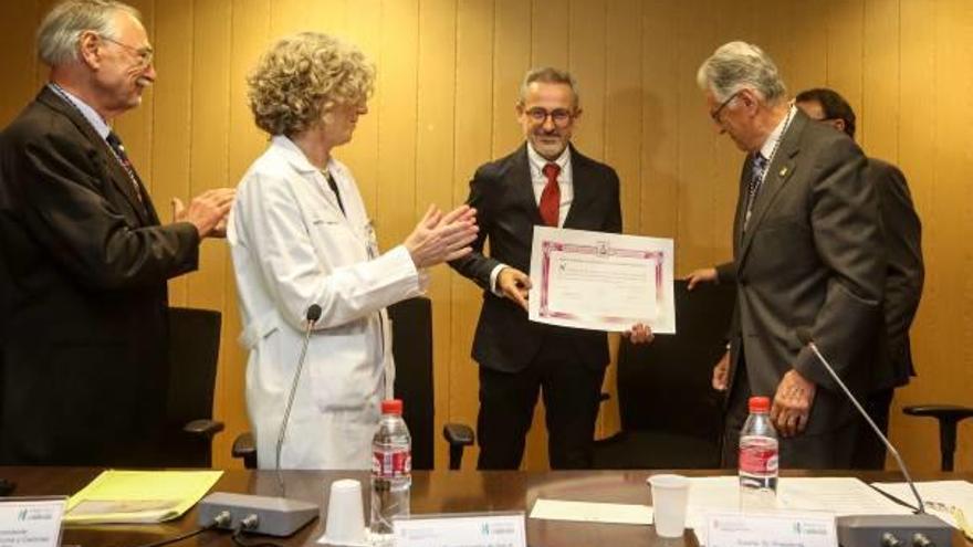 Israel Oliver, con el diploma de la Academia, entre la gerente del departamento y otros académicos.