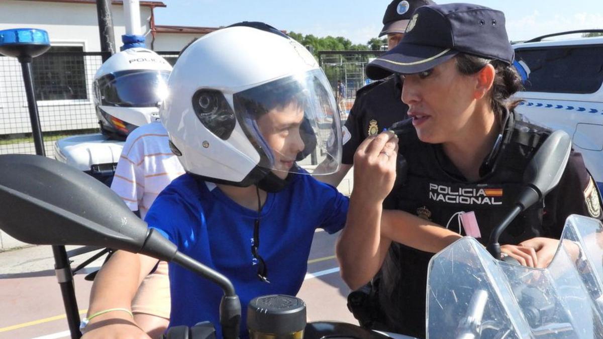 Una agente habla con un niño subido a una moto policial.