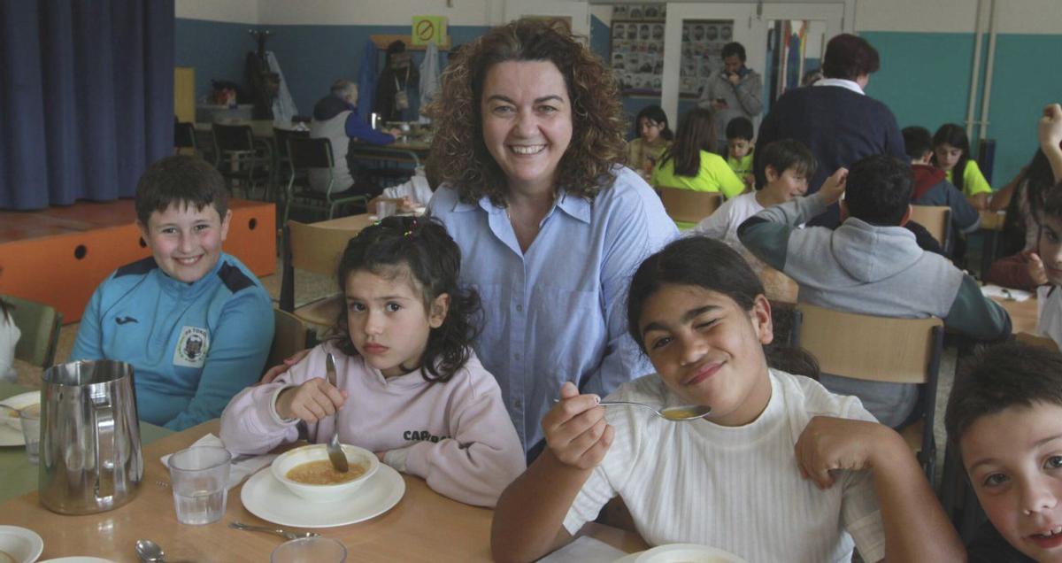 La directora, Cruz Estévez, con un grupo de alumnos en el comedor. | IÑAKI OSORIO