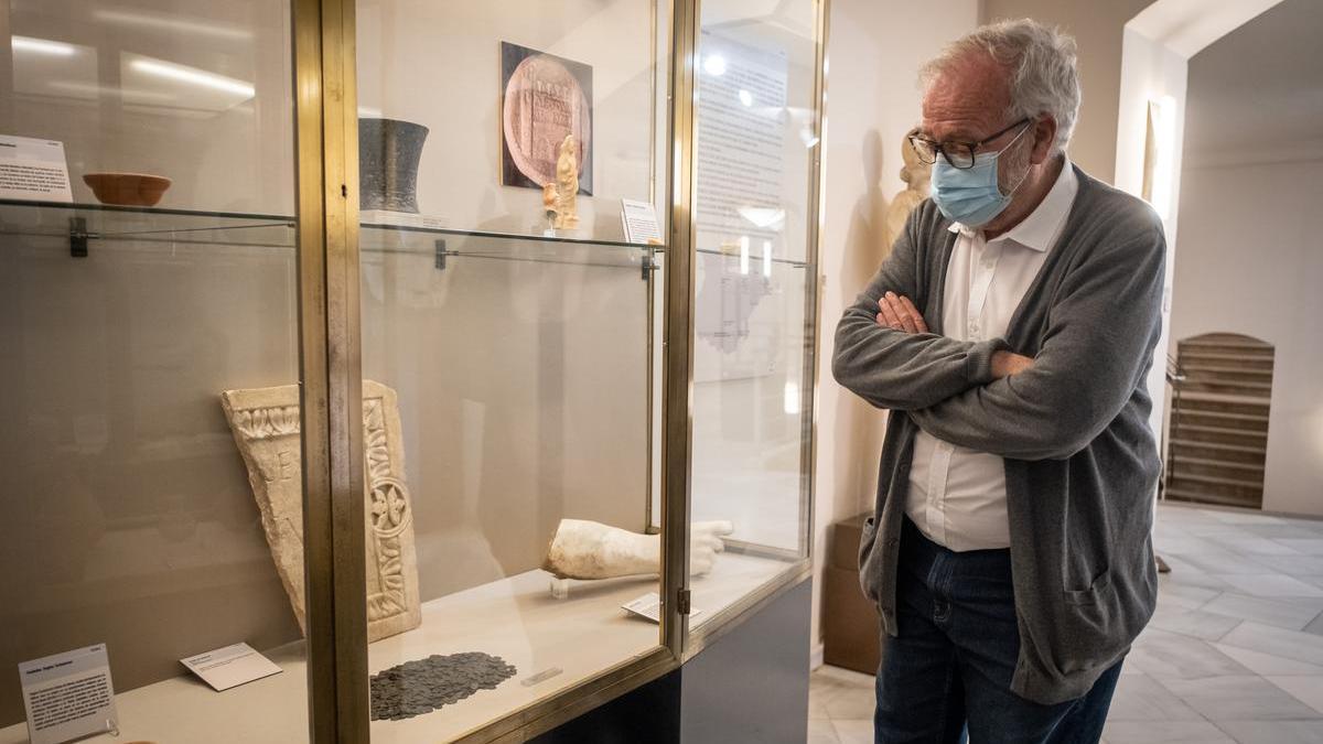 El director del Museo Arqueológico de Badajoz, Guillermo Kurtz, observa las monedas.
