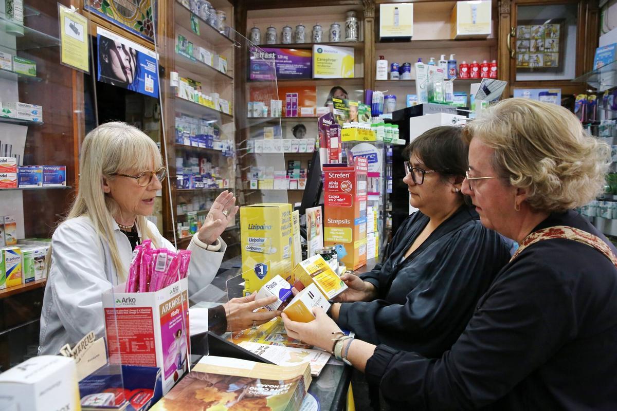 Dos clientas reciben asesoramiento sobre medicamentos para la menopausia en la farmacia.
