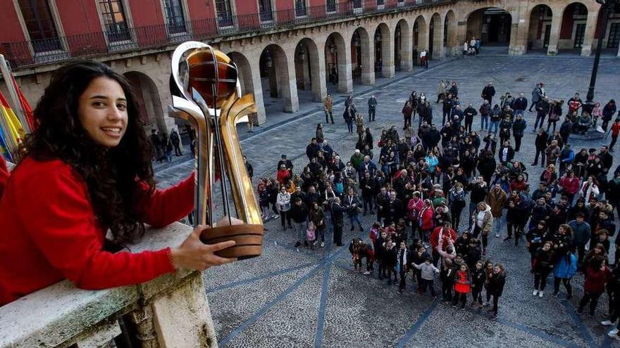 Sara González muestra la Copa de Europa a los aficionados desde el balcón del Ayuntamiento.