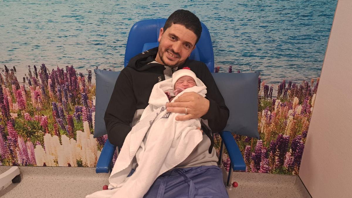 El padre, con la pequeña en brazos.