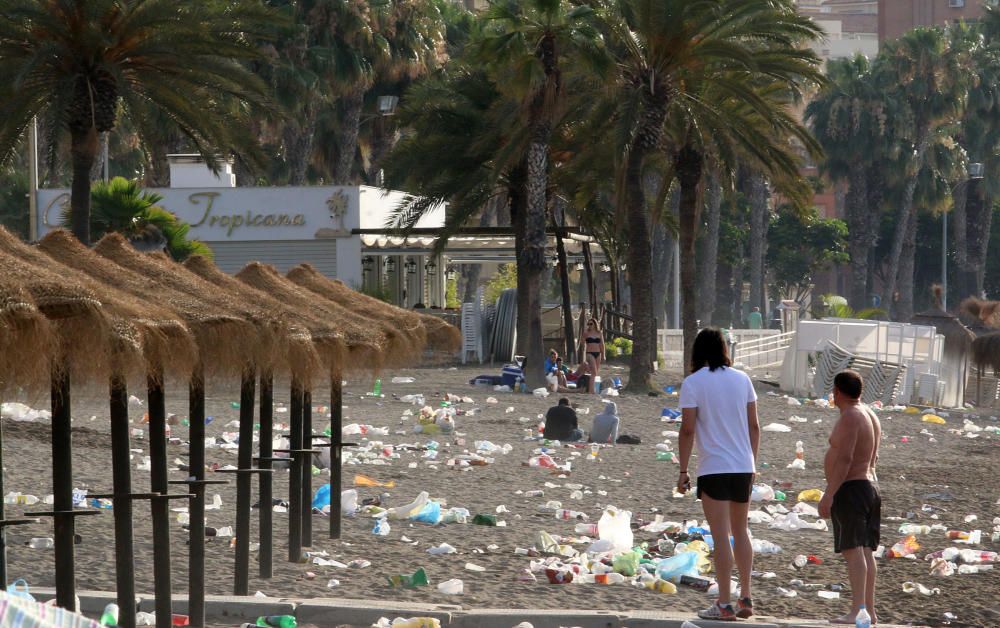 Los operarios de los servicios de limpieza trabajan para dejar la playa en óptimas condiciones tras una larga noche de fiesta en la arena